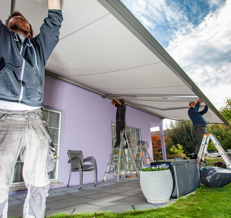  Collaborateurs Val Stores qui montent un store extérieur