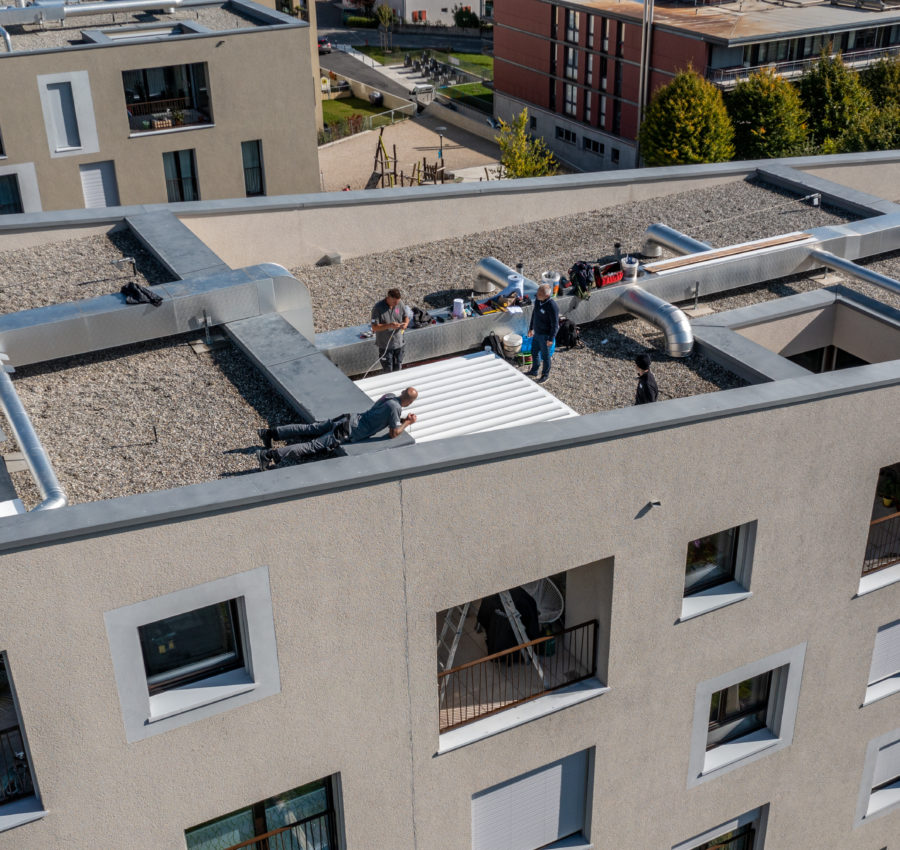  Collaborateurs Burgener qui installent une pergola sur un immeuble